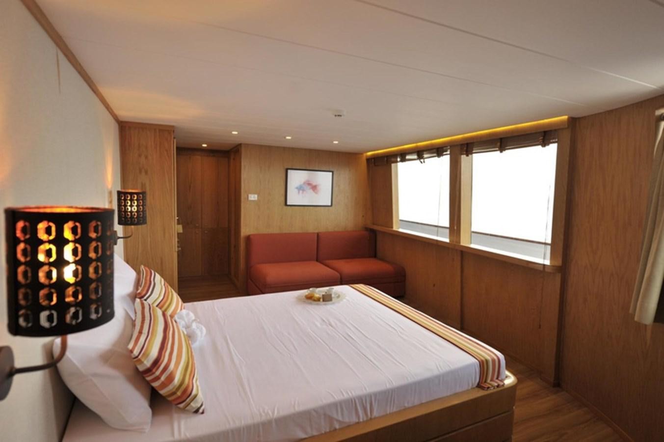 a bed with a white sheet and pillows on it aboard 2017 SAFARI  142 CUSTOM Yacht for Sale