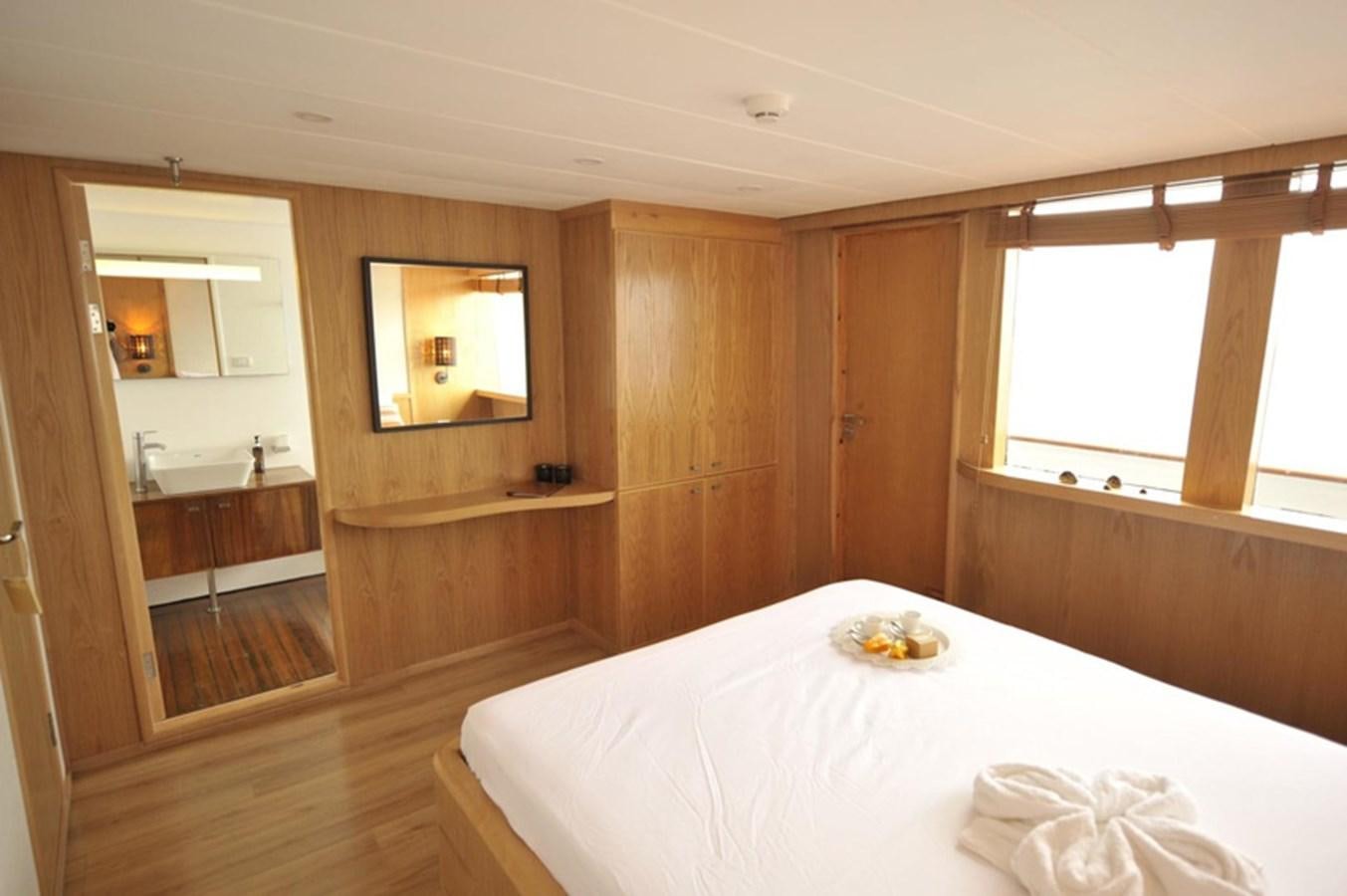 a room with a table and a bed aboard 2017 SAFARI  142 CUSTOM Yacht for Sale
