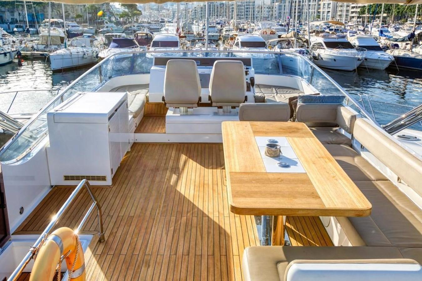 a deck with a view of a marina with boats and a city in the background aboard LANA 1 Yacht for Sale