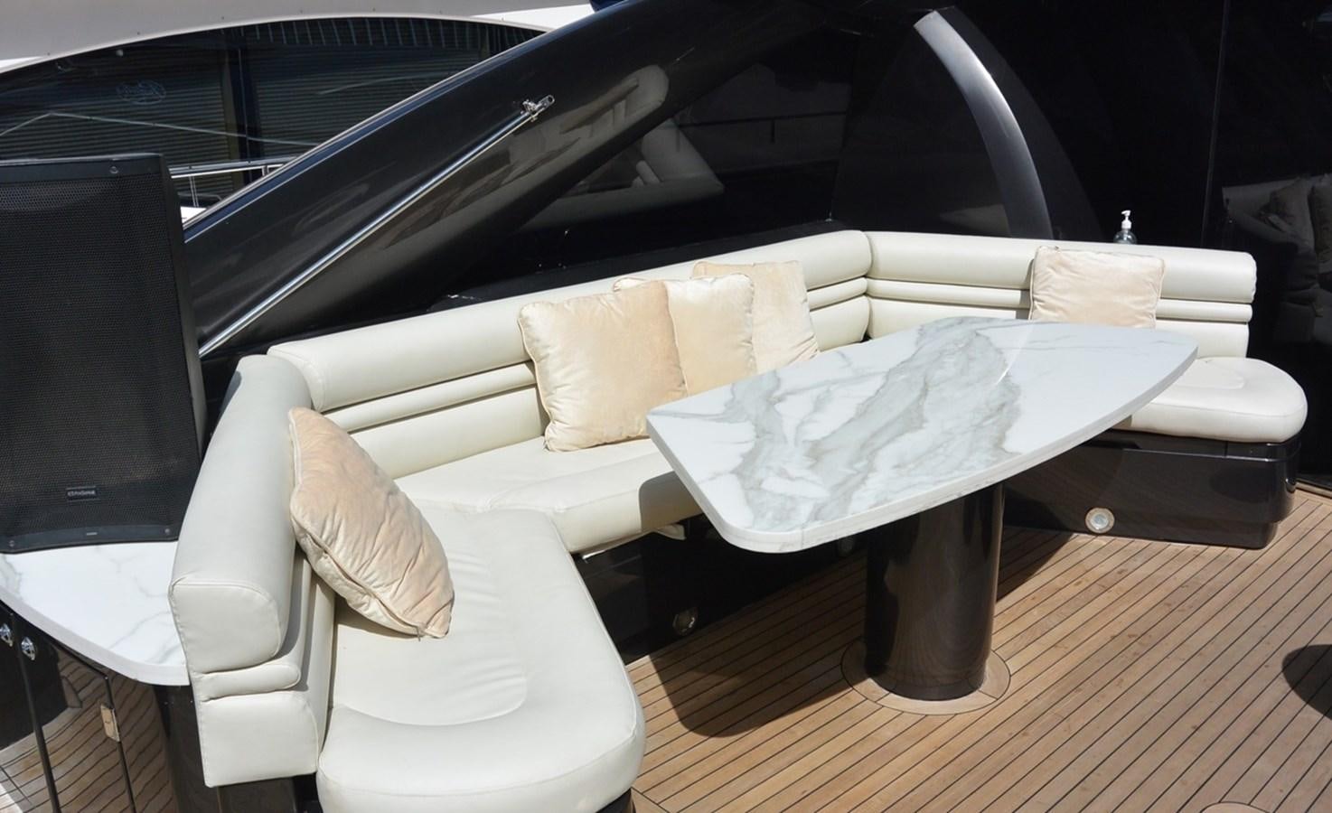 a white couch with a white table and chairs in front of a car aboard 2004 SUNSEEKER PREDATOR 95 Yacht for Sale