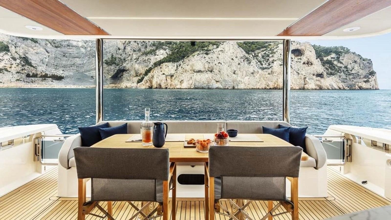 a table on a deck overlooking a body of water aboard LEGEND II Yacht for Sale