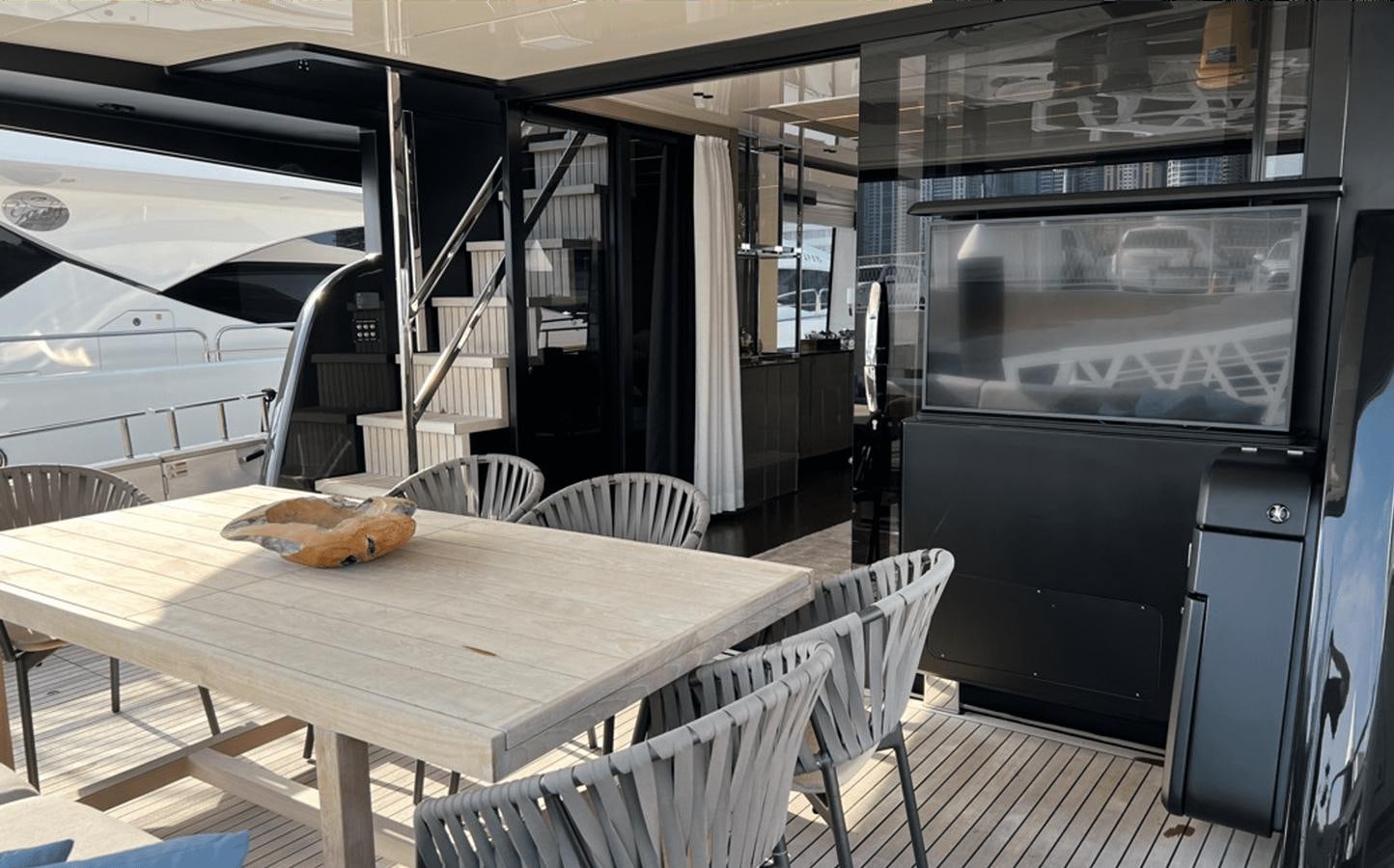 a table with chairs and a tv aboard 2022 CRANCHI 78 Yacht for Sale