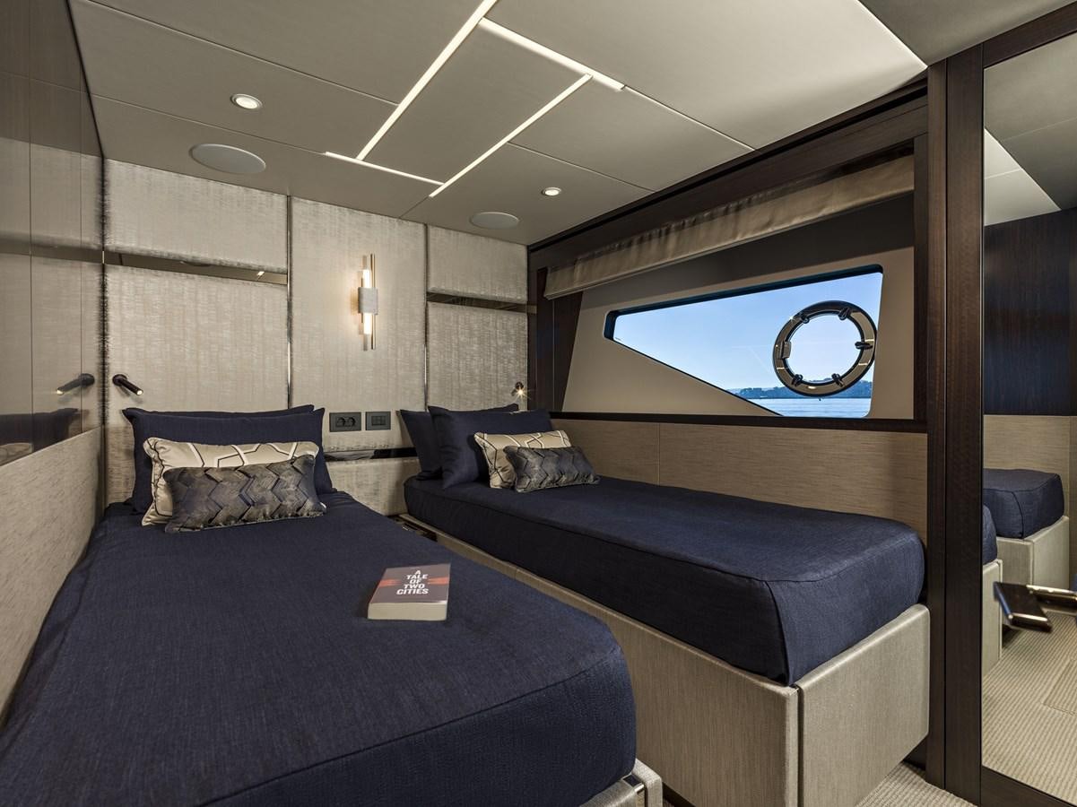 a bedroom with a blue couch aboard JUNIOR Yacht for Sale