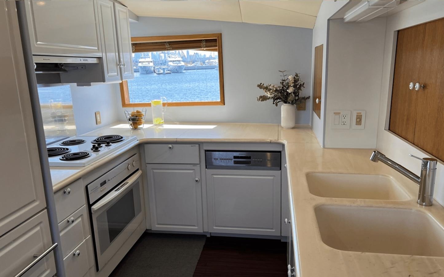 a kitchen with white cabinets aboard 1998 HATTERAS 92 Yacht for Sale