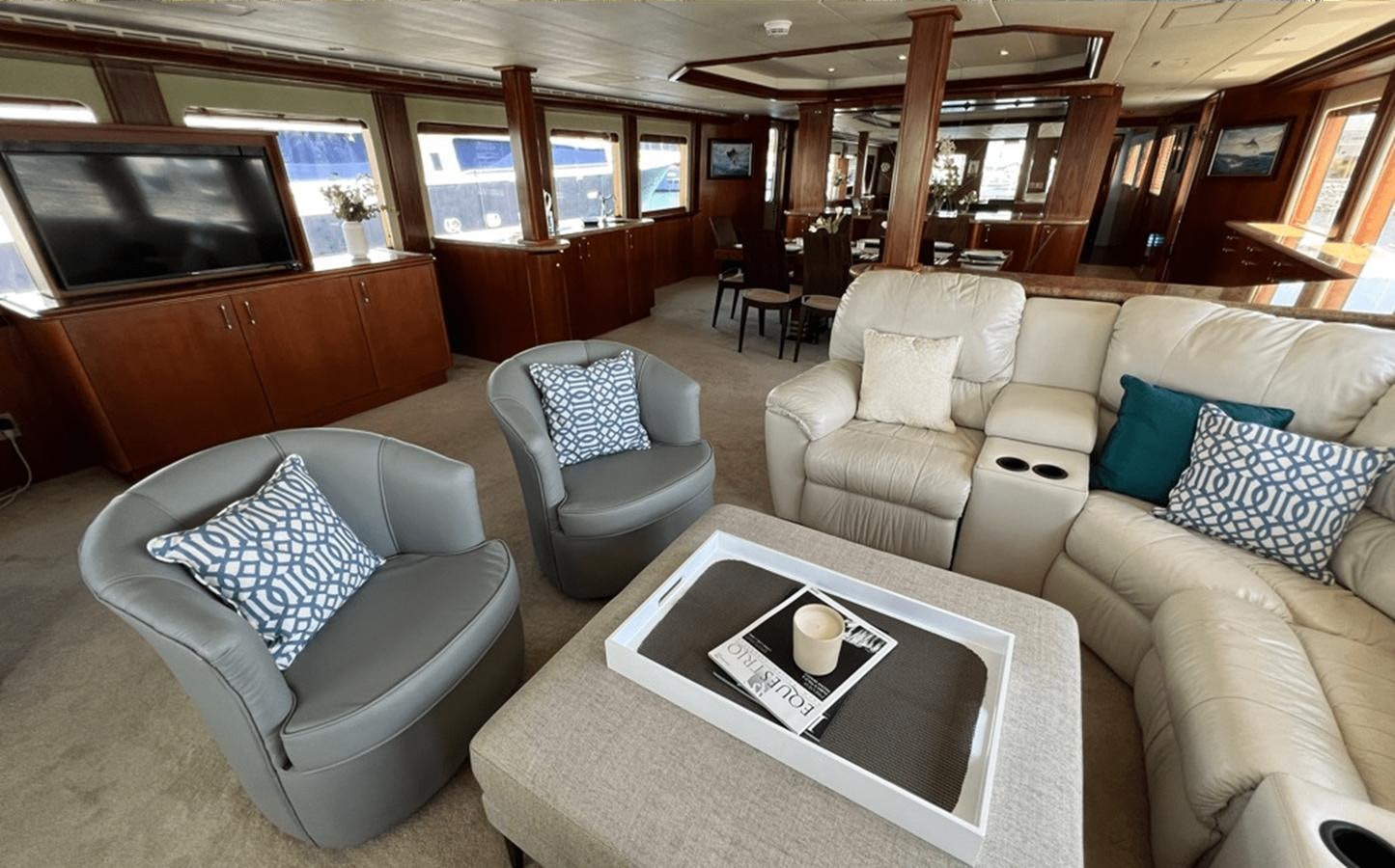 a living room with couches and a television aboard 1998 HATTERAS 92 Yacht for Sale