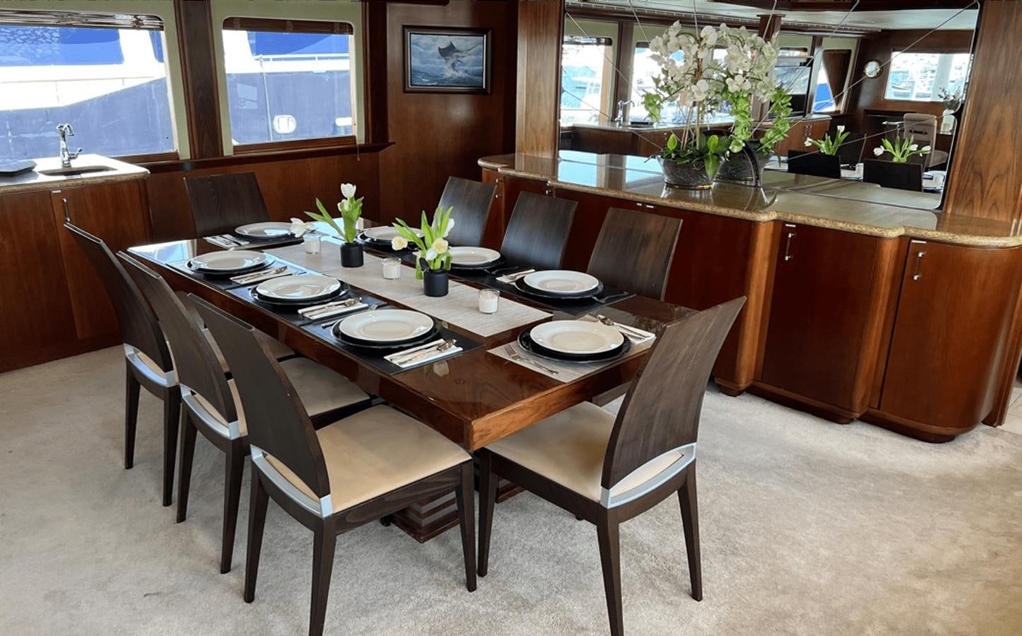 a table with plates and chairs aboard 1998 HATTERAS 92 Yacht for Sale