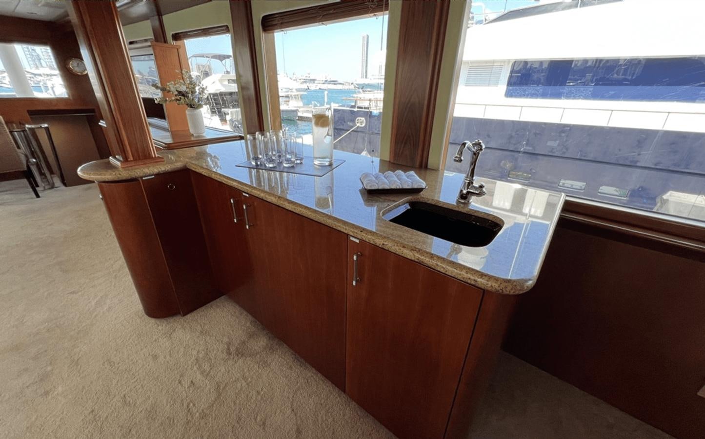 a counter with wine glasses on it aboard 1998 HATTERAS 92 Yacht for Sale