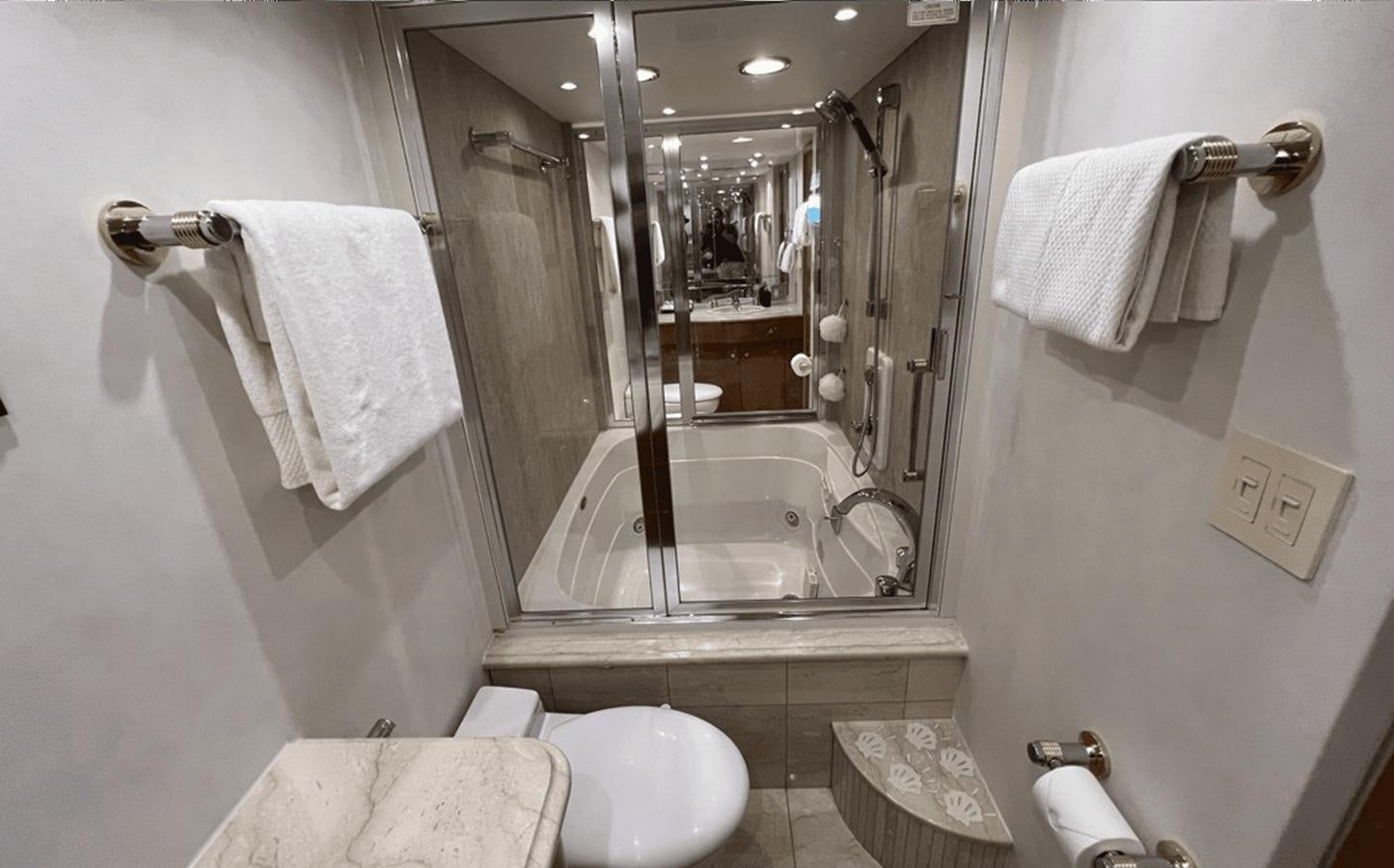 a bathroom with a glass shower aboard 1998 HATTERAS 92 Yacht for Sale
