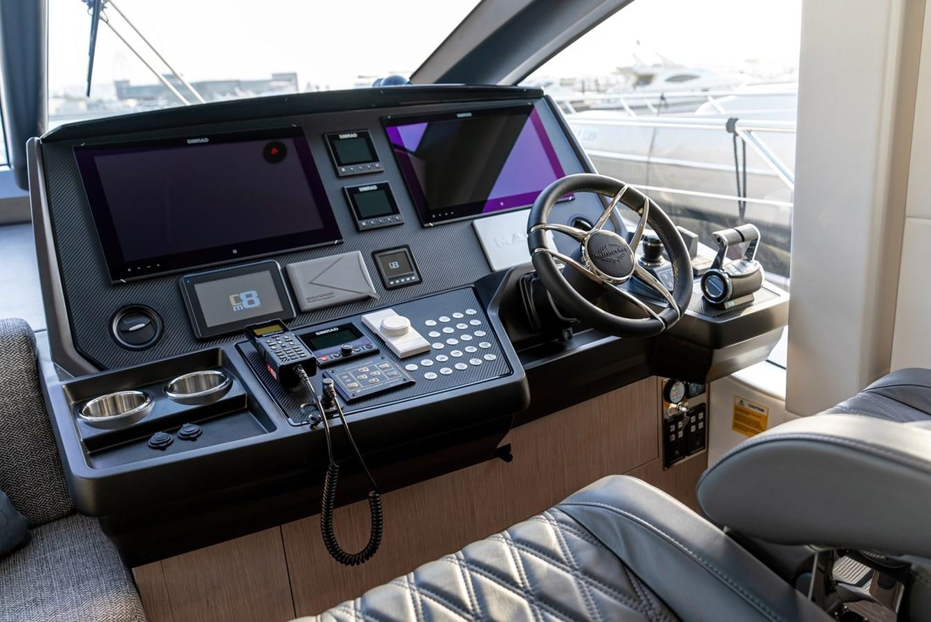 a desk with a computer and other electronics on it aboard 2023 SUNSEEKER 74 SPORTS  XPS Yacht for Sale