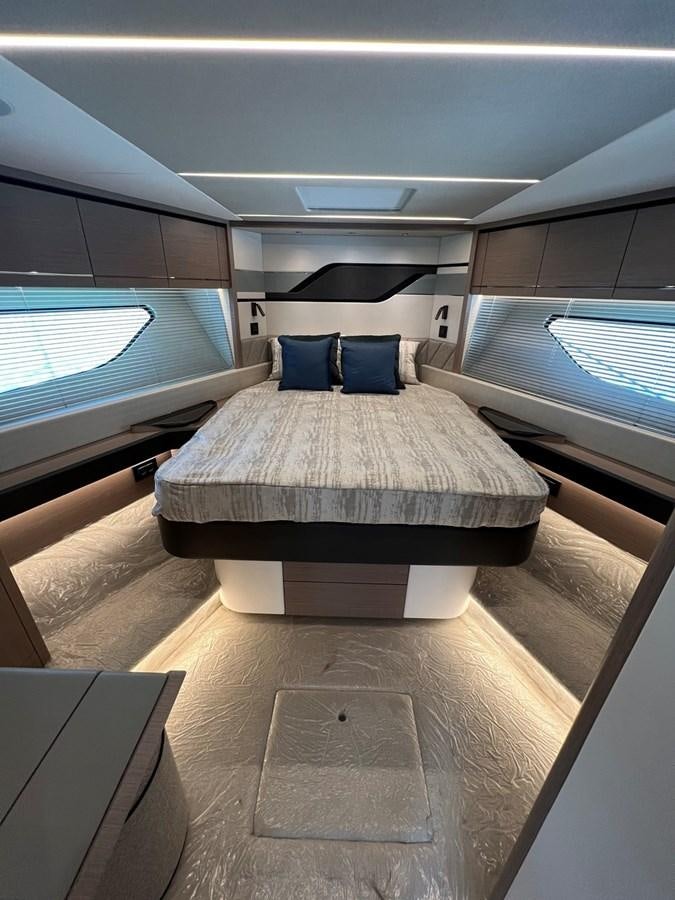 a room with a bed and a window aboard 2023 SUNSEEKER 74 SPORTS  XPS Yacht for Sale