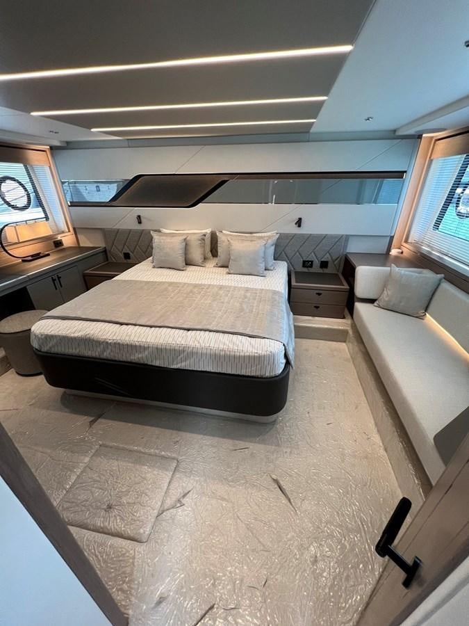 a bedroom with a bed and a couch aboard 2023 SUNSEEKER 74 SPORTS  XPS Yacht for Sale