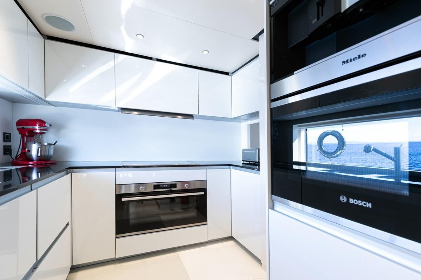 a kitchen with white cabinets aboard JAG'B Yacht for Sale