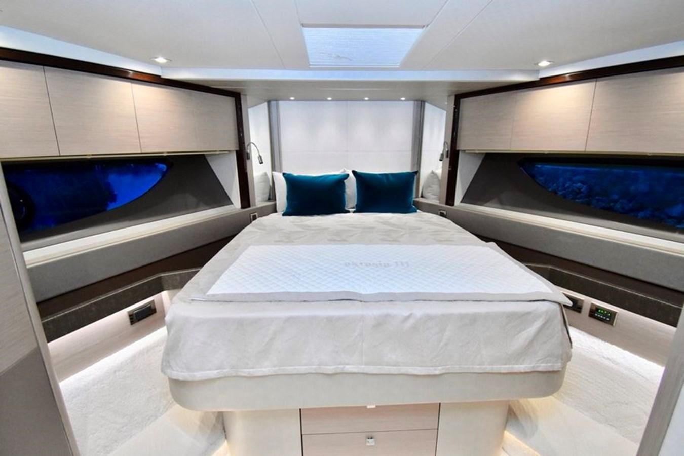 a room with a bed and a couple of blue pillows aboard DO  ANYWAY Yacht for Sale