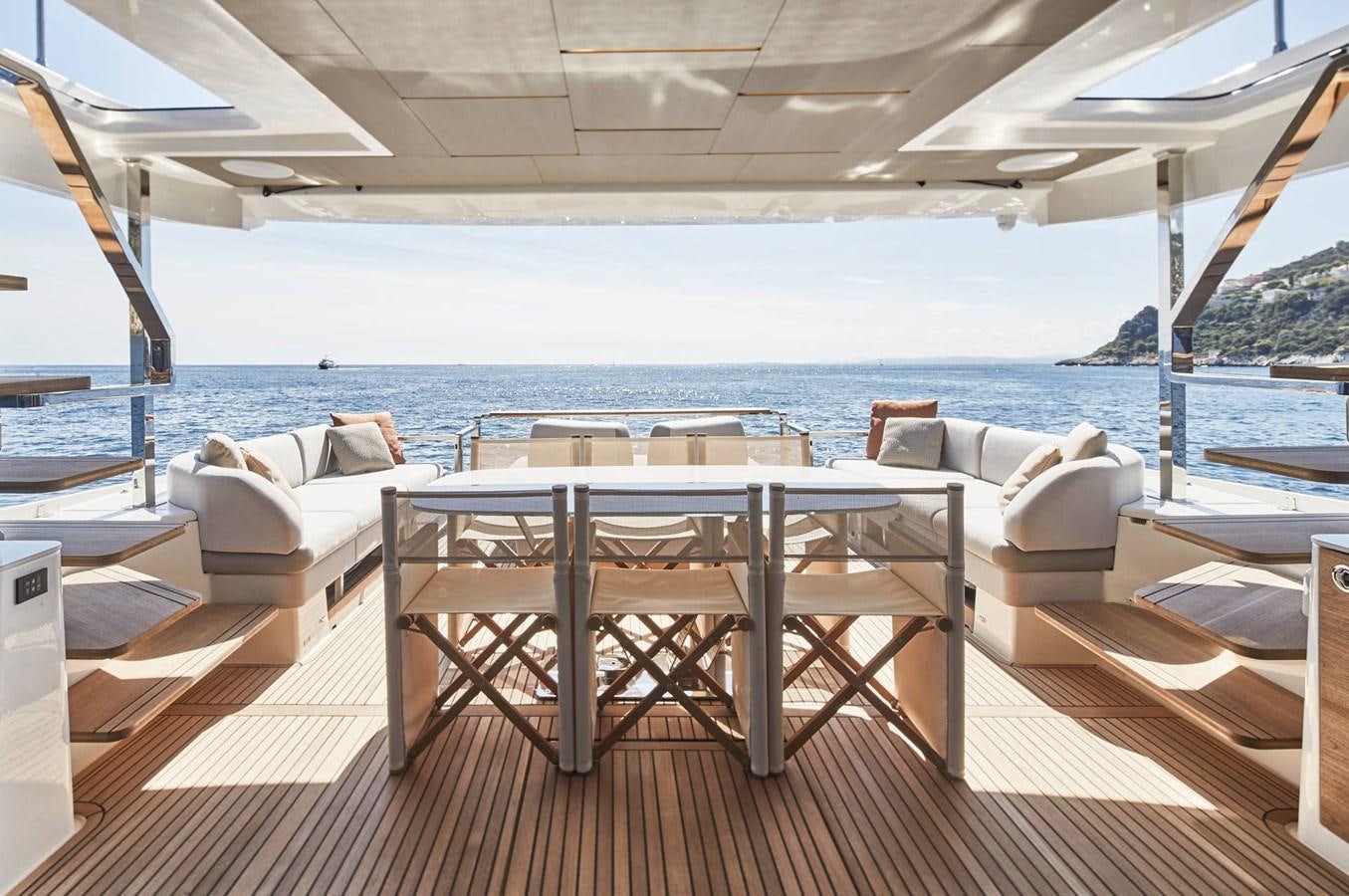 a table and chairs on a deck overlooking a body of water aboard 2024 PRESTIGE X-LINE X70 Yacht for Sale