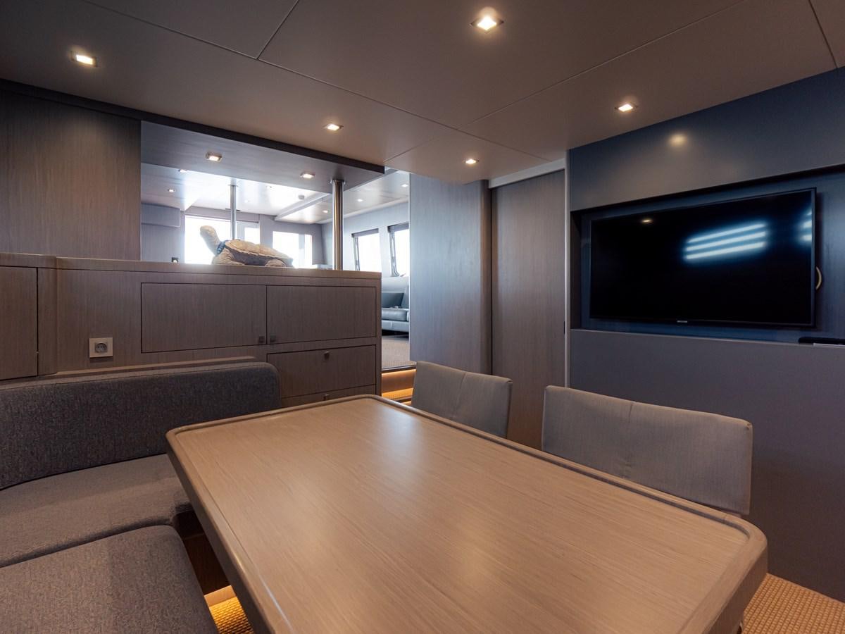 a room with a table and couches aboard HELIAD III Yacht for Sale
