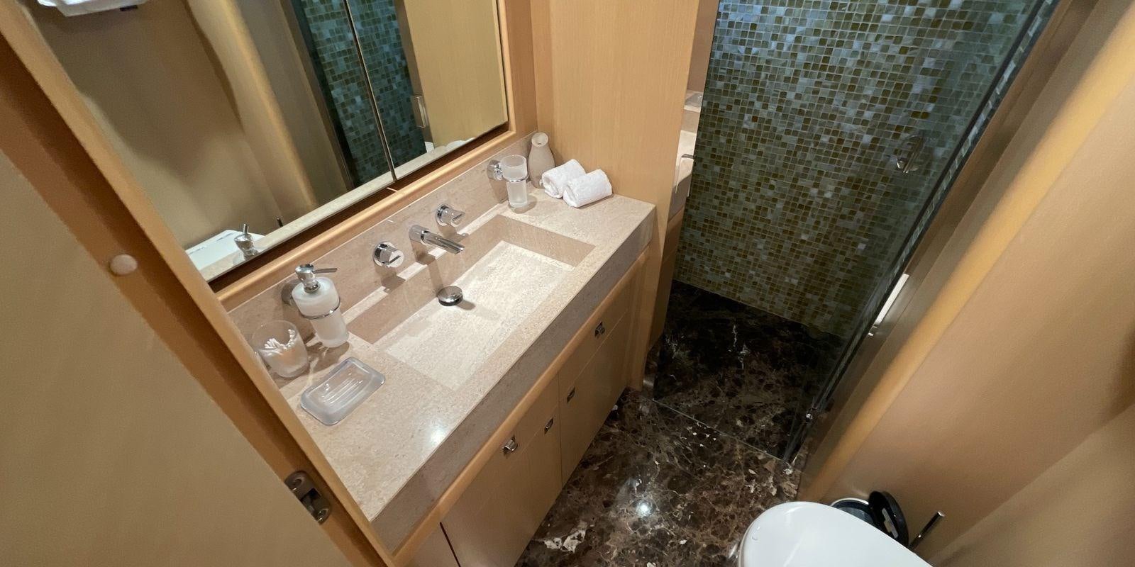a bathroom with a countertop sink and a large mirror aboard PRINCESS 21M Yacht for Sale