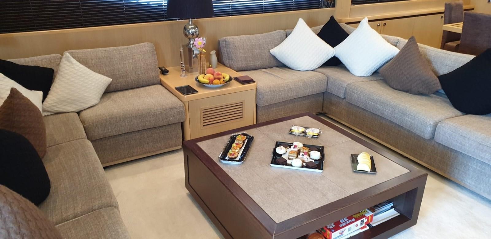 a living room with a couch and coffee table aboard PRINCESS 21M Yacht for Sale