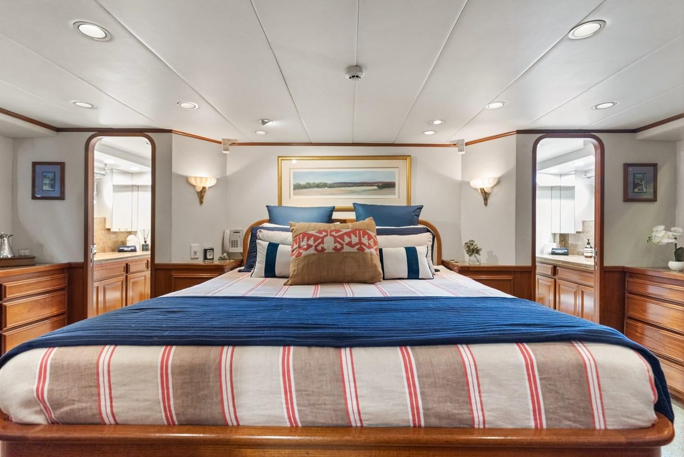 a bed with a blue and red striped bed spread aboard HUNTRESS Yacht for Sale