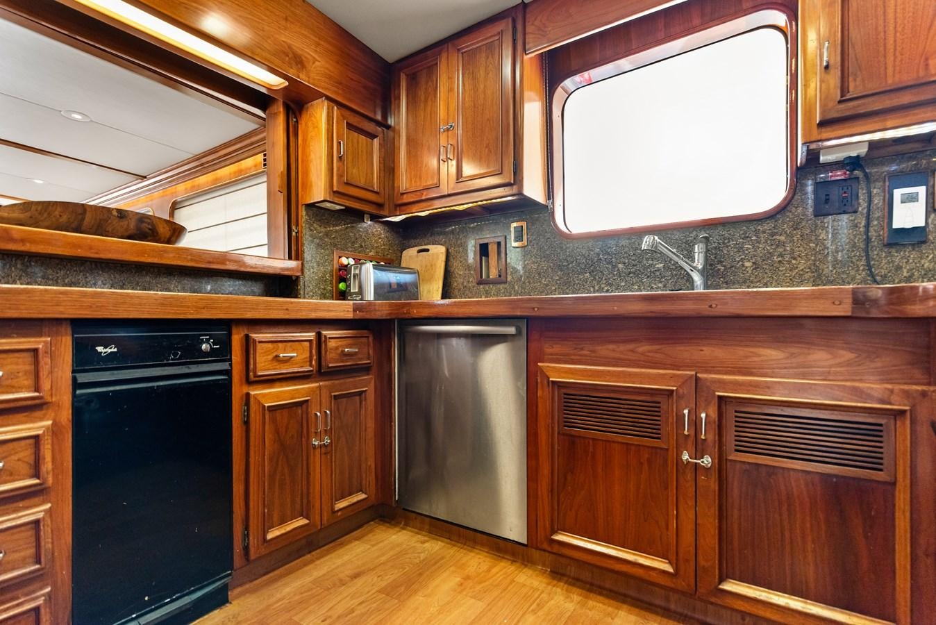 a kitchen with wooden cabinets aboard HUNTRESS Yacht for Sale