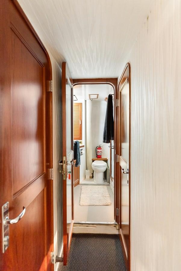 a bathroom with a toilet and a door aboard HUNTRESS Yacht for Sale