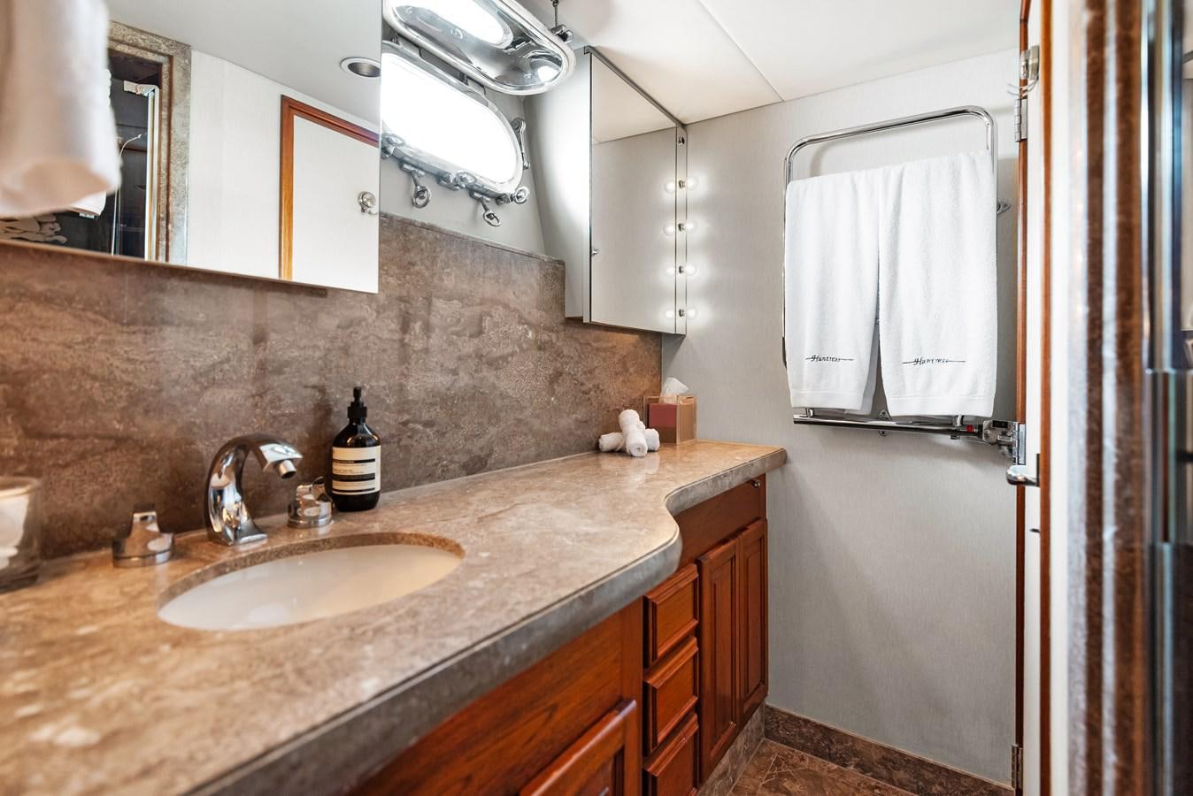 a bathroom with a countertop sink and a mirror aboard HUNTRESS Yacht for Sale