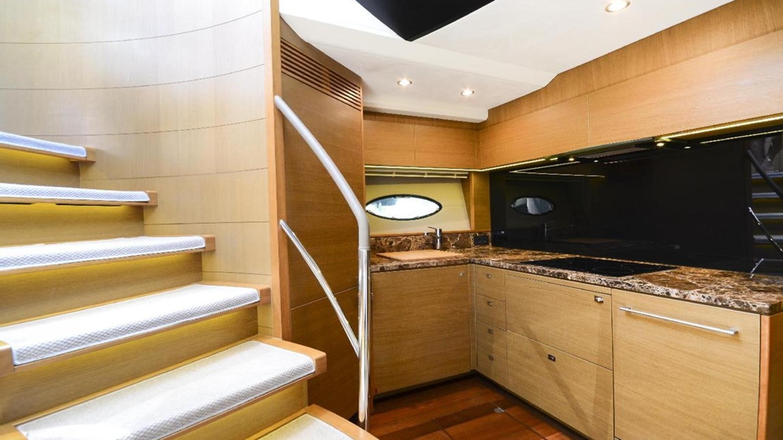a kitchen with wooden cabinets aboard NAVY Yacht for Sale