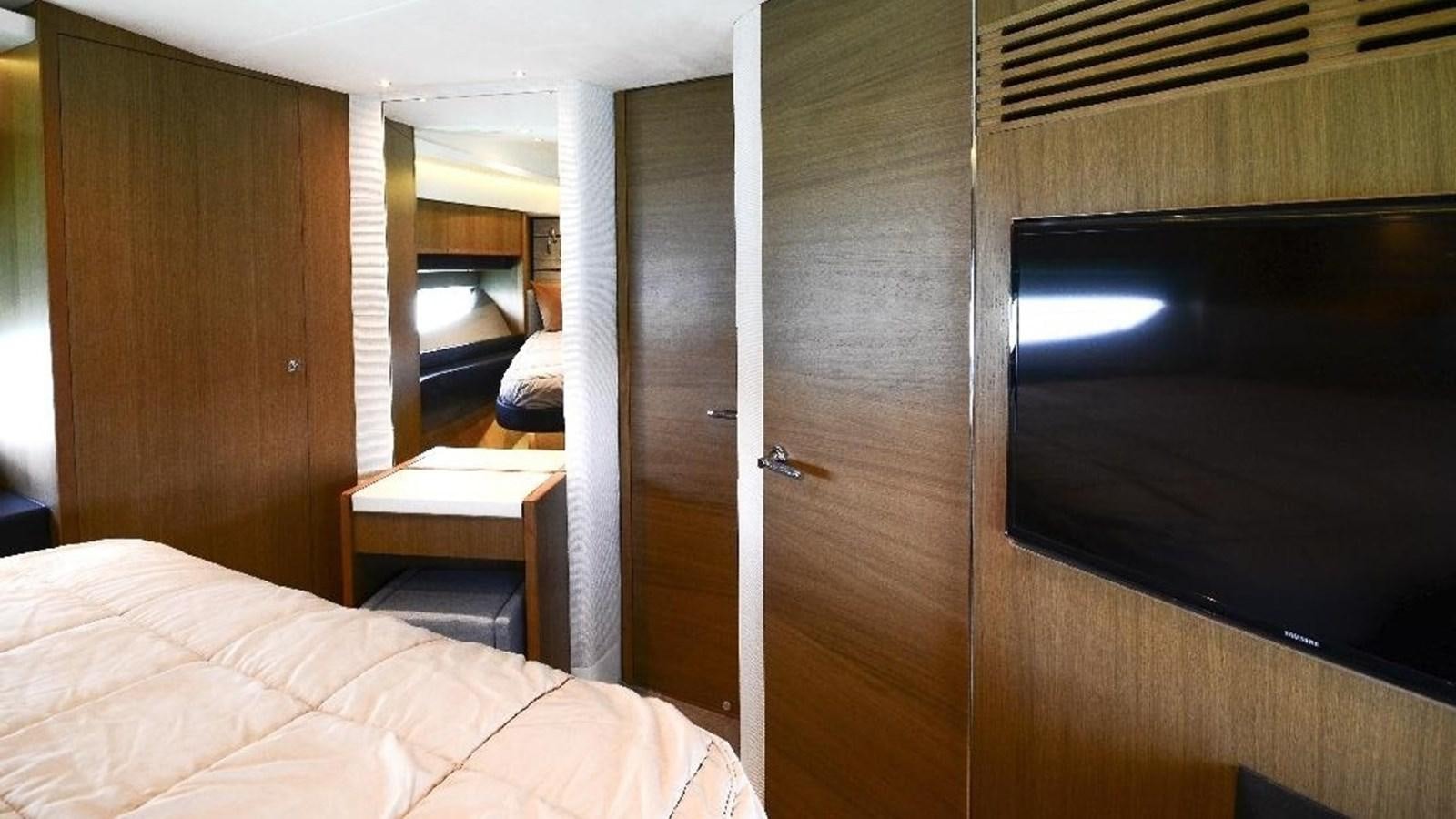a room with a bed and a television aboard NAVY Yacht for Sale