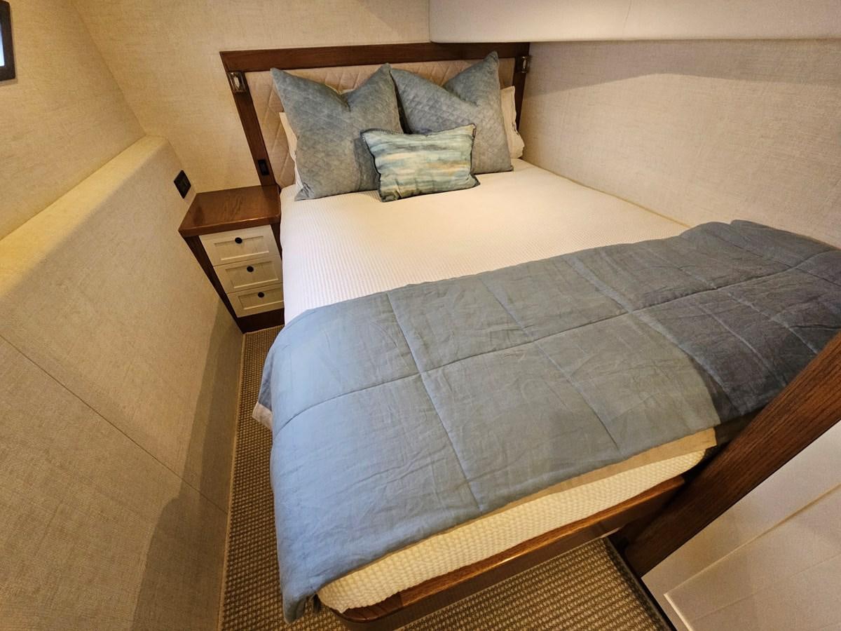 a bed with a blue comforter aboard THE KEYS Yacht for Sale