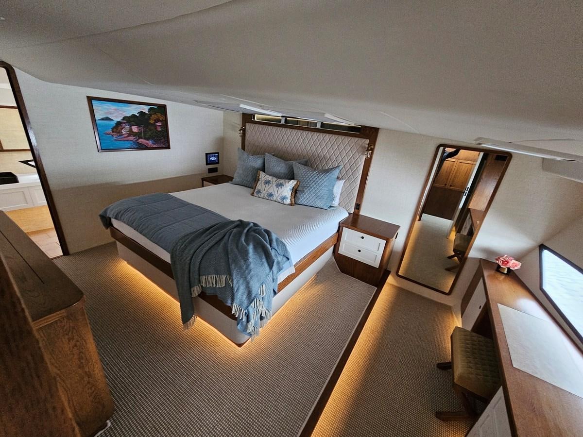 a bedroom with a bed and a desk aboard THE KEYS Yacht for Sale