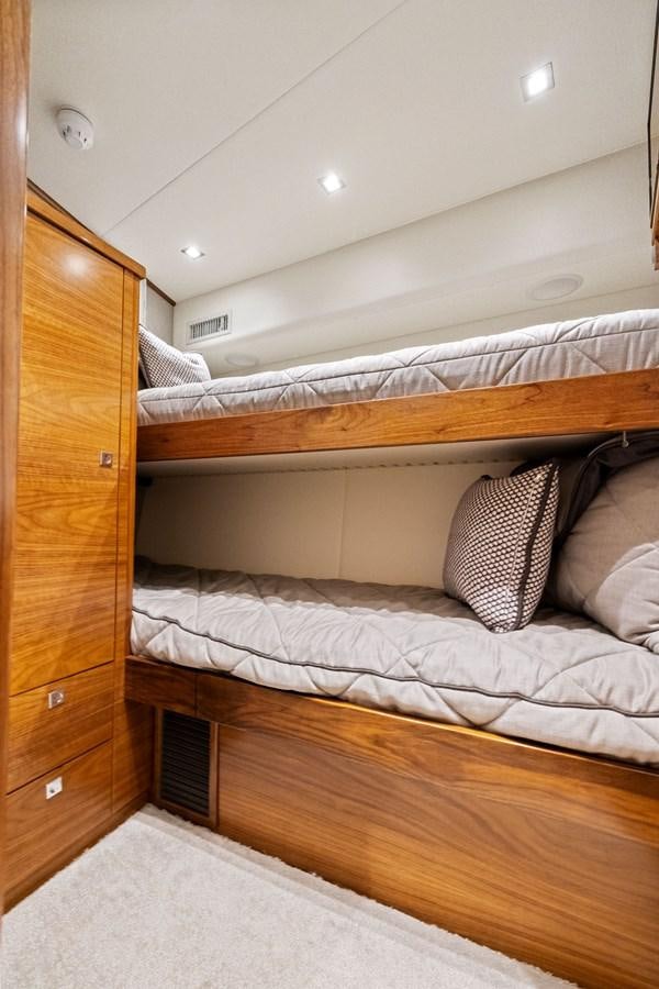a bed with a wooden headboard aboard ZATARA Yacht for Sale