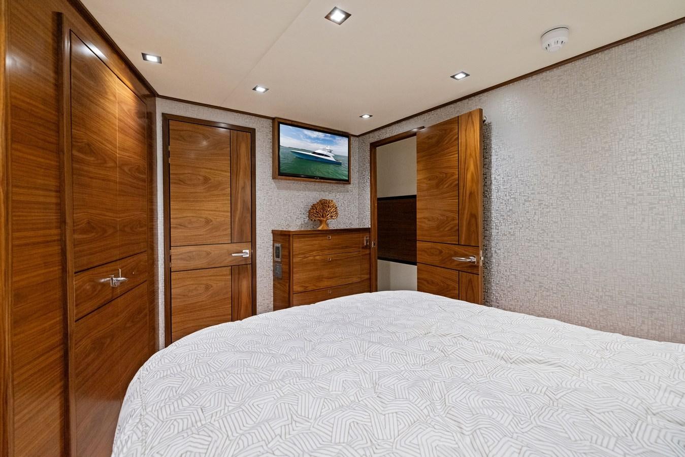 a bedroom with a bed and wooden cabinets aboard ZATARA Yacht for Sale