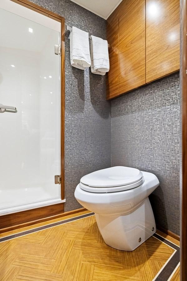 a bathroom with a toilet and wooden cabinets aboard ZATARA Yacht for Sale