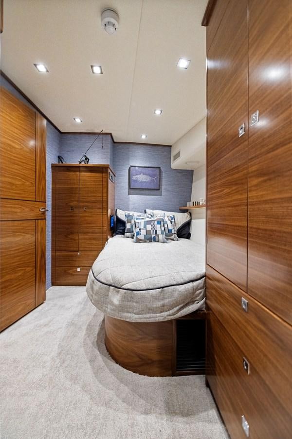 a bedroom with a bed and wooden cabinets aboard ZATARA Yacht for Sale