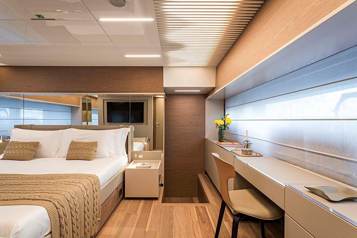 a bedroom with a bed and a desk aboard ANINHA I Yacht for Sale