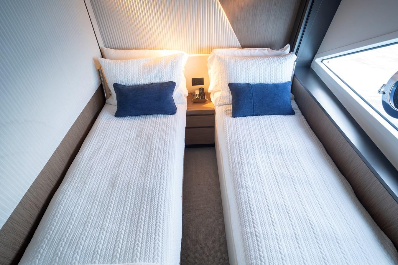 a bed with a white sheet and blue pillows aboard SILVER MOON Yacht for Sale