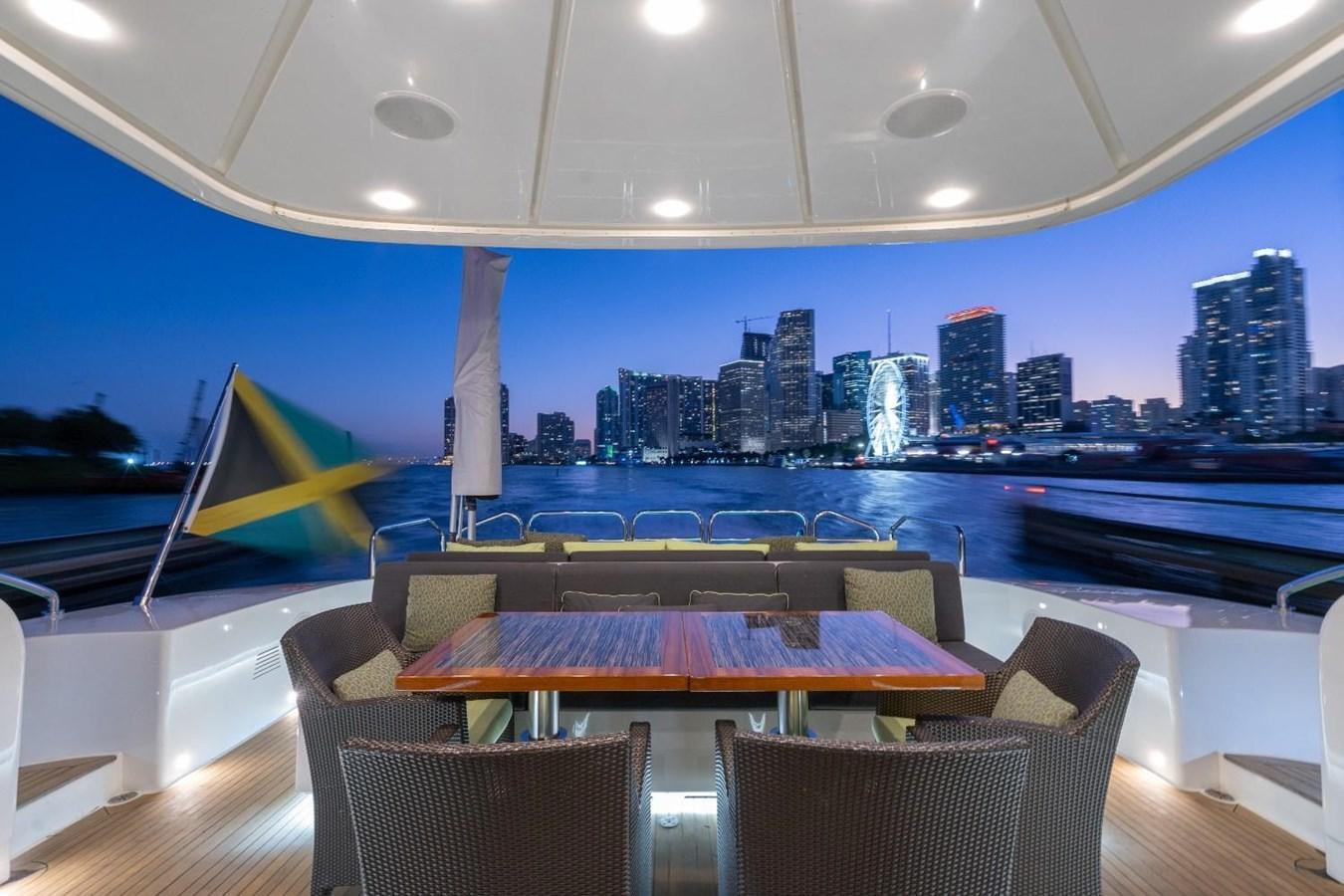 a table and chairs on a deck overlooking a city aboard LEOPARD Yacht for Sale