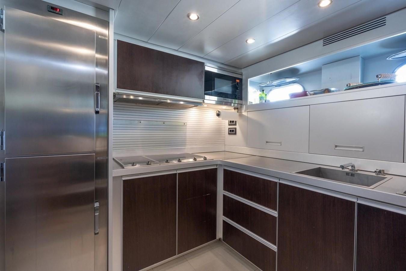 a kitchen with a stainless steel refrigerator aboard LEOPARD Yacht for Sale