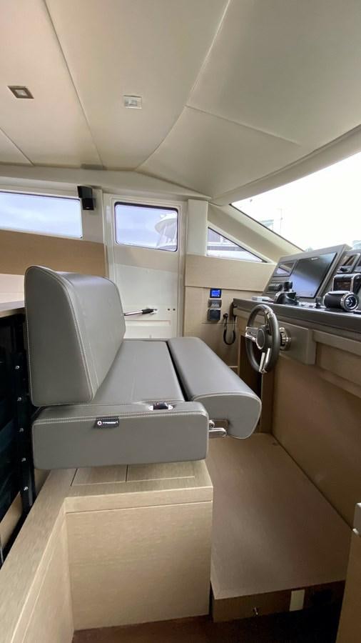 a room with a seat and a computer on the wall aboard 2016 PRESTIGE  750 Yacht for Sale