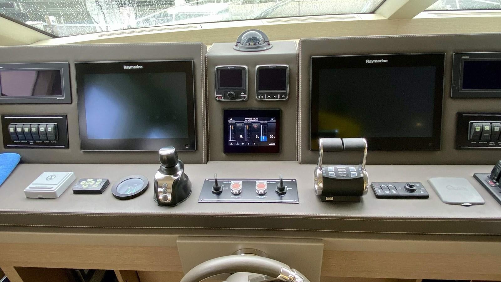a group of electronic devices on a table aboard 2016 PRESTIGE  750 Yacht for Sale