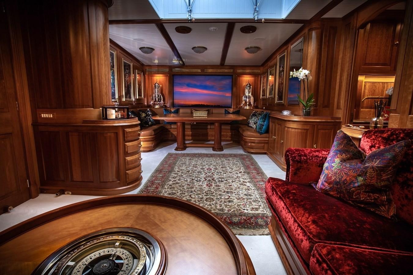 a living room with a large table and a tv aboard LETHANTIA Yacht for Sale