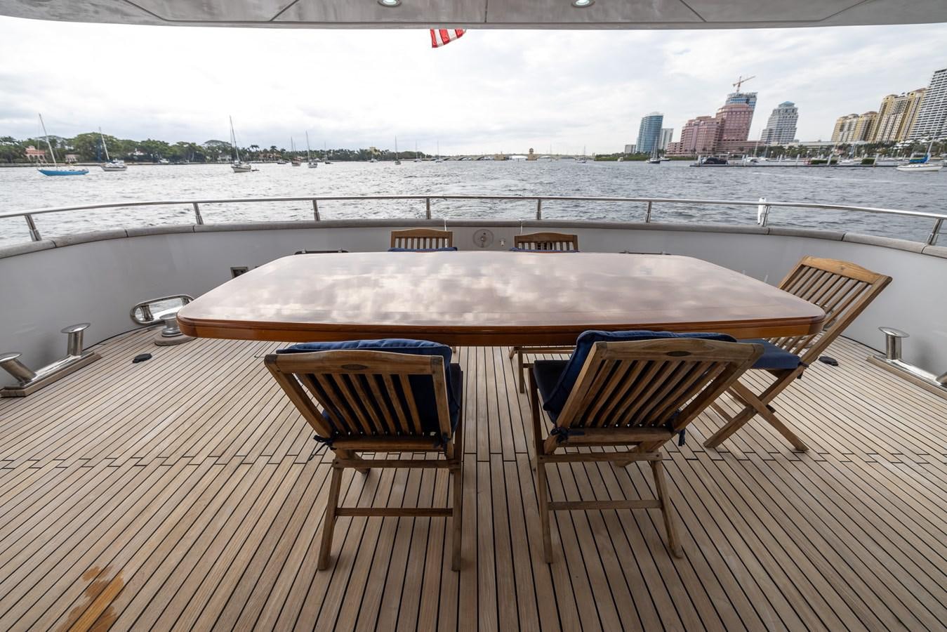 a table and chairs on a deck overlooking a city aboard ENDLESS SUN Yacht for Sale