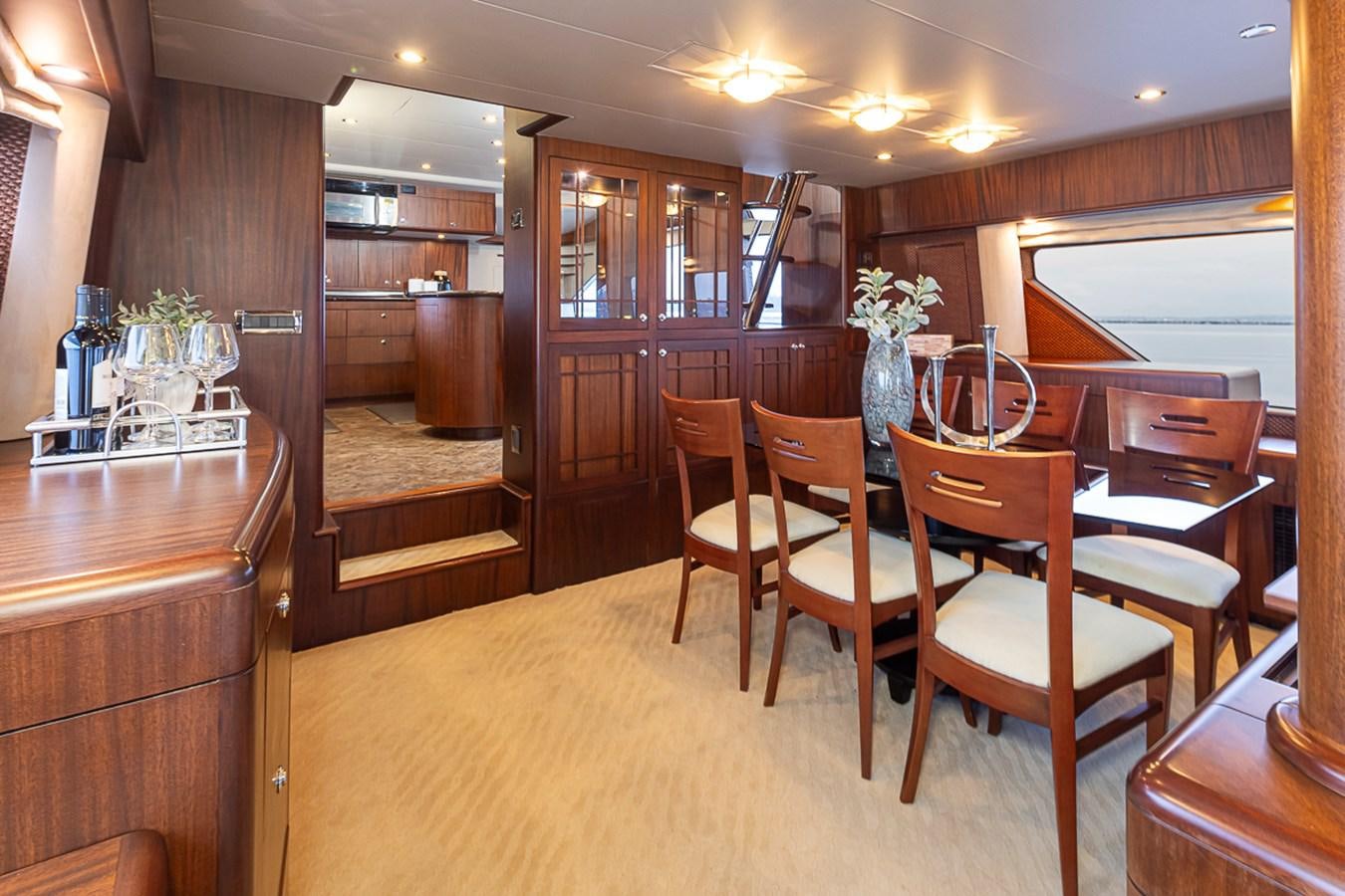 a room with a table chairs and cabinets aboard SEA SPUR Yacht for Sale