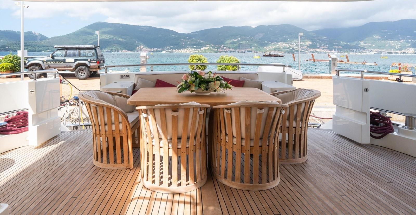 a table on a deck overlooking a body of water aboard JASMINE LUNA Yacht for Sale