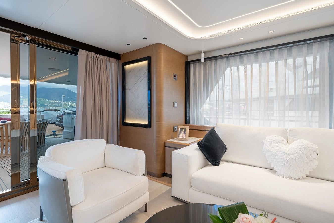 a living room with a white couch and a large window aboard JASMINE LUNA Yacht for Sale