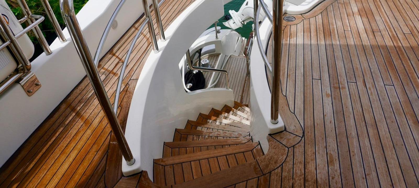 a wooden staircase with a white railing aboard OUR TIME Yacht for Sale