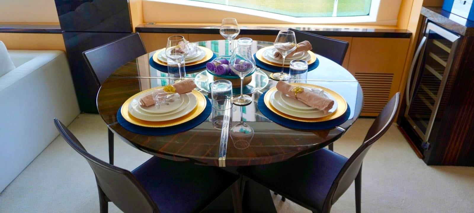 a table with plates and glasses on it aboard OUR TIME Yacht for Sale