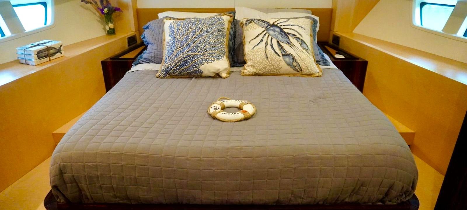 a bed with a pillow and a tray of cookies on it aboard OUR TIME Yacht for Sale