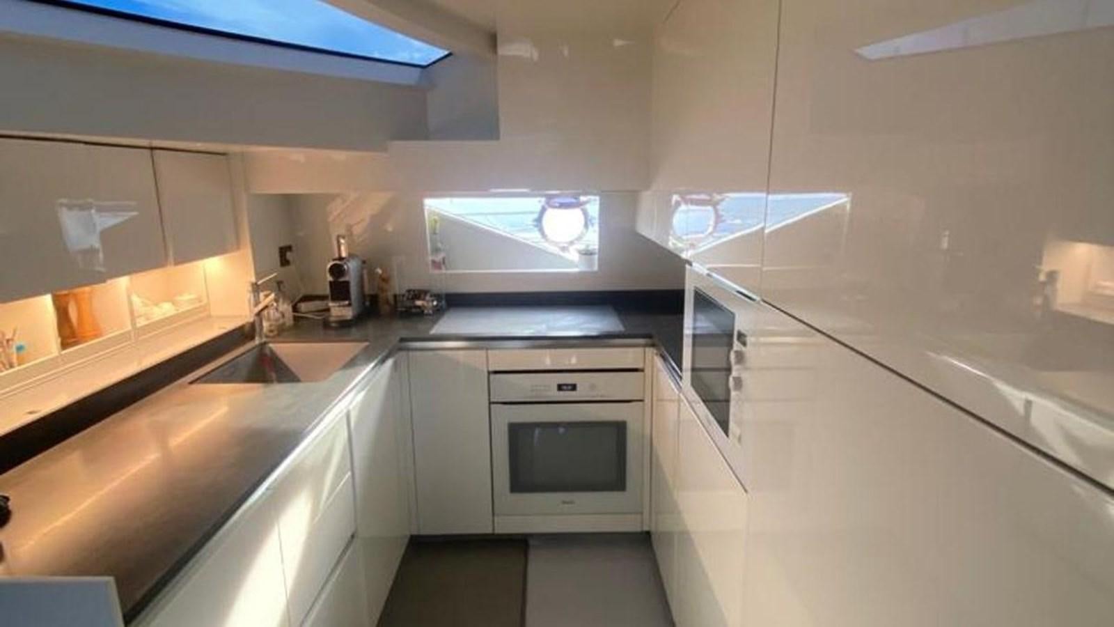 a kitchen with white cabinets aboard NUMERO 5 Yacht for Sale