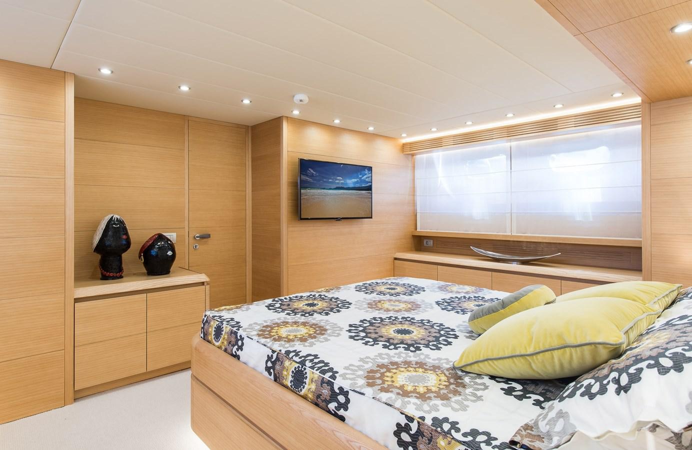 a bedroom with a bed and a wood cabinet aboard MIREDO Yacht for Sale