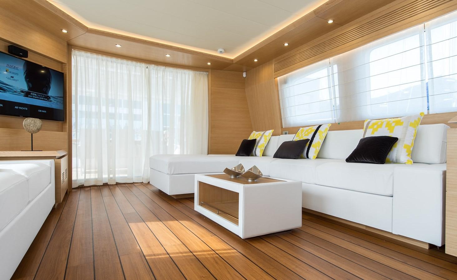 a living room with a large white couch and a television aboard MIREDO Yacht for Sale